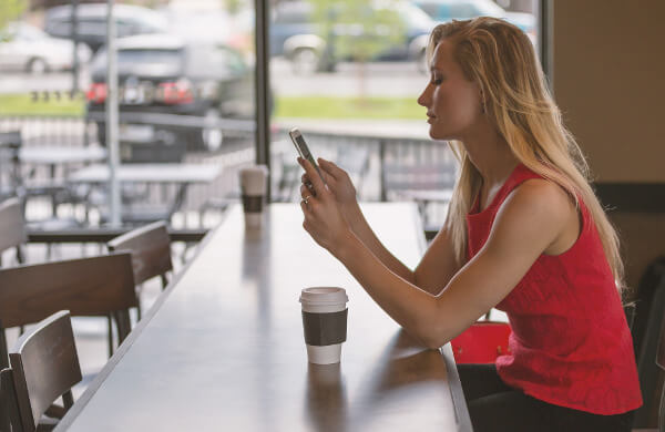 Frau mit Smartphone im Kaffee